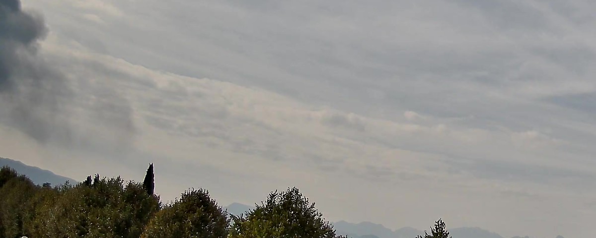 La colonna di fumo vista dalla webcam ovest di Thiene si allunga verso destra, davanti alle Prealpi vicentine